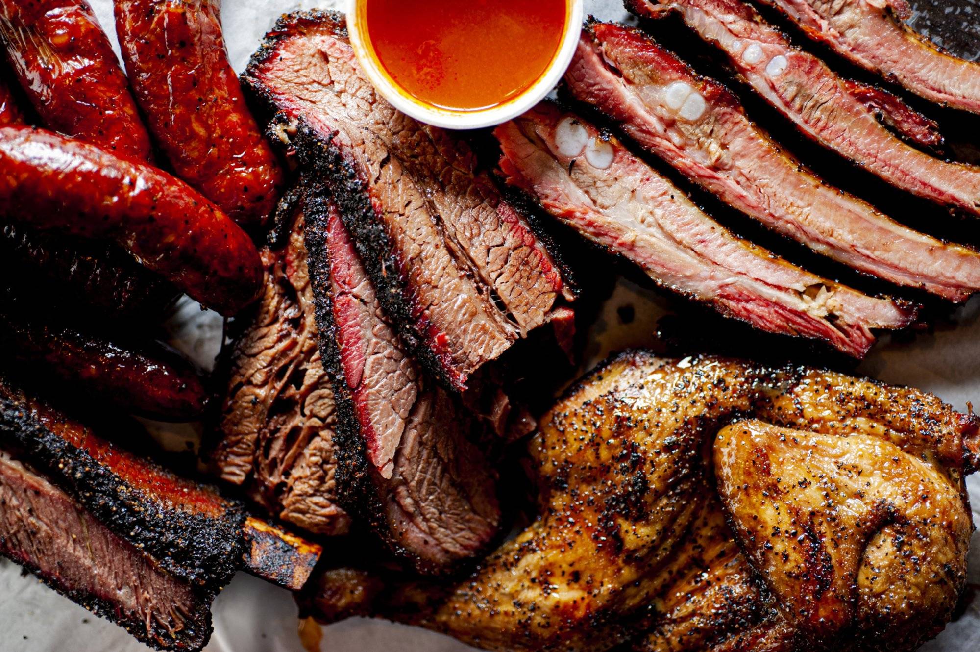 Barbecue. Barbecue table spread. Beef brisket, chicken, pork ribs, beef ribs, Mac n cheese, cornbread, Brussels sprouts, coleslaw & beer. Classic traditional Texas meats & side dishes.